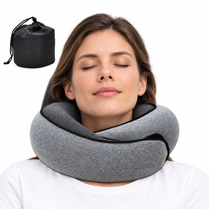 A woman wearing a gray neck pillow with black trim, shown against a white background with a small black drawstring storage pouch in the upper left corner.
