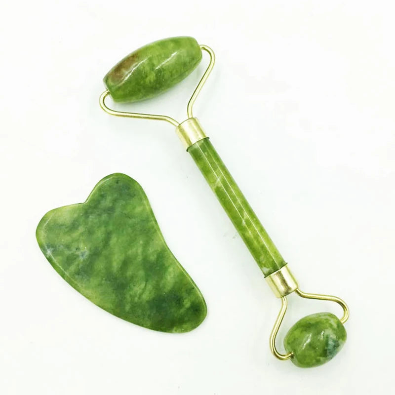 Green jade roller and gua sha tool on a white background