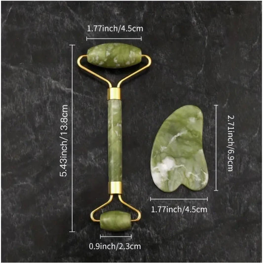 Green jade roller and gua sha tool with measurements on a dark surface