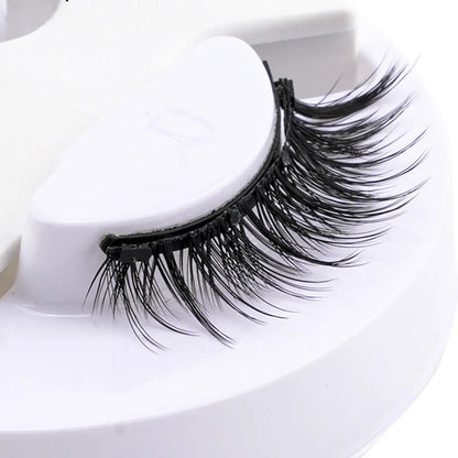 Pair of false eyelashes on a white stand.