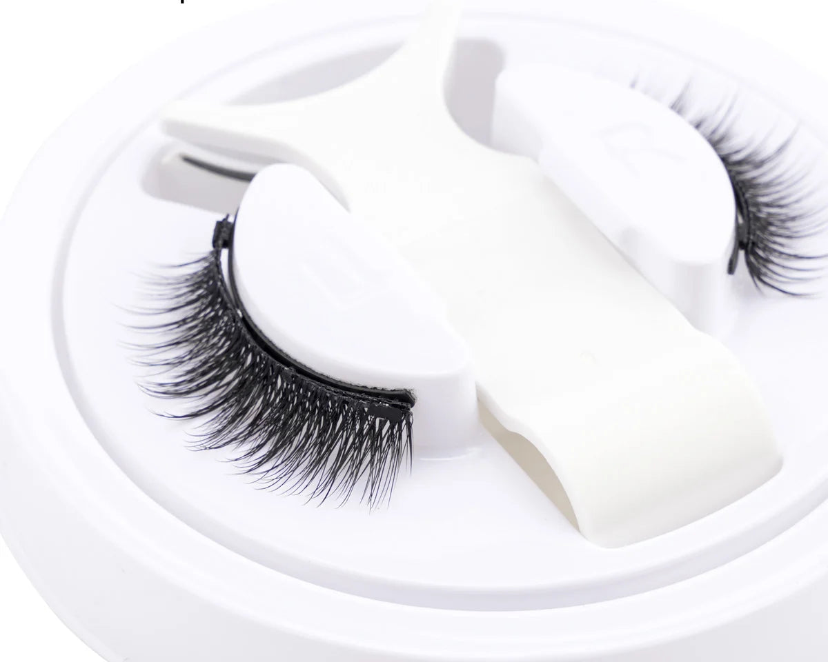 Pair of false eyelashes on a white stand.