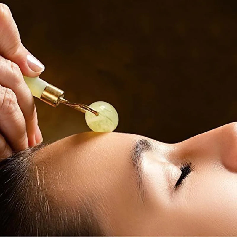 Person applying a dropper of liquid to the skin on a dark background