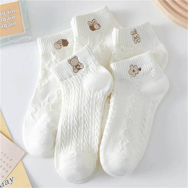 Set of white socks with embroidered designs on a light background