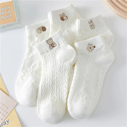 Set of white socks with embroidered designs on a light background