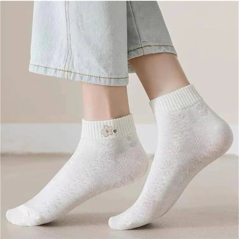 White socks with a subtle pattern worn by a person on a neutral background