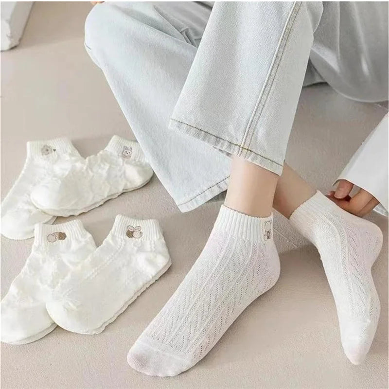 White textured socks worn by a person with additional pairs displayed on a neutral surface.