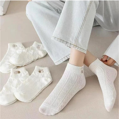 White textured socks worn by a person with additional pairs displayed on a neutral surface.