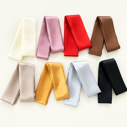 Set of colorful satin ribbons on a white surface