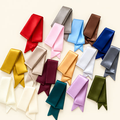 Collection of folded satin ribbons in various colors on a white background