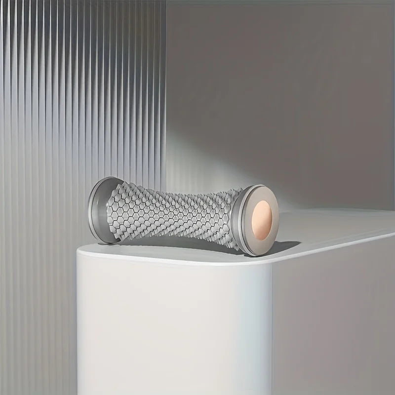 grey manual foot massage roller on white surface